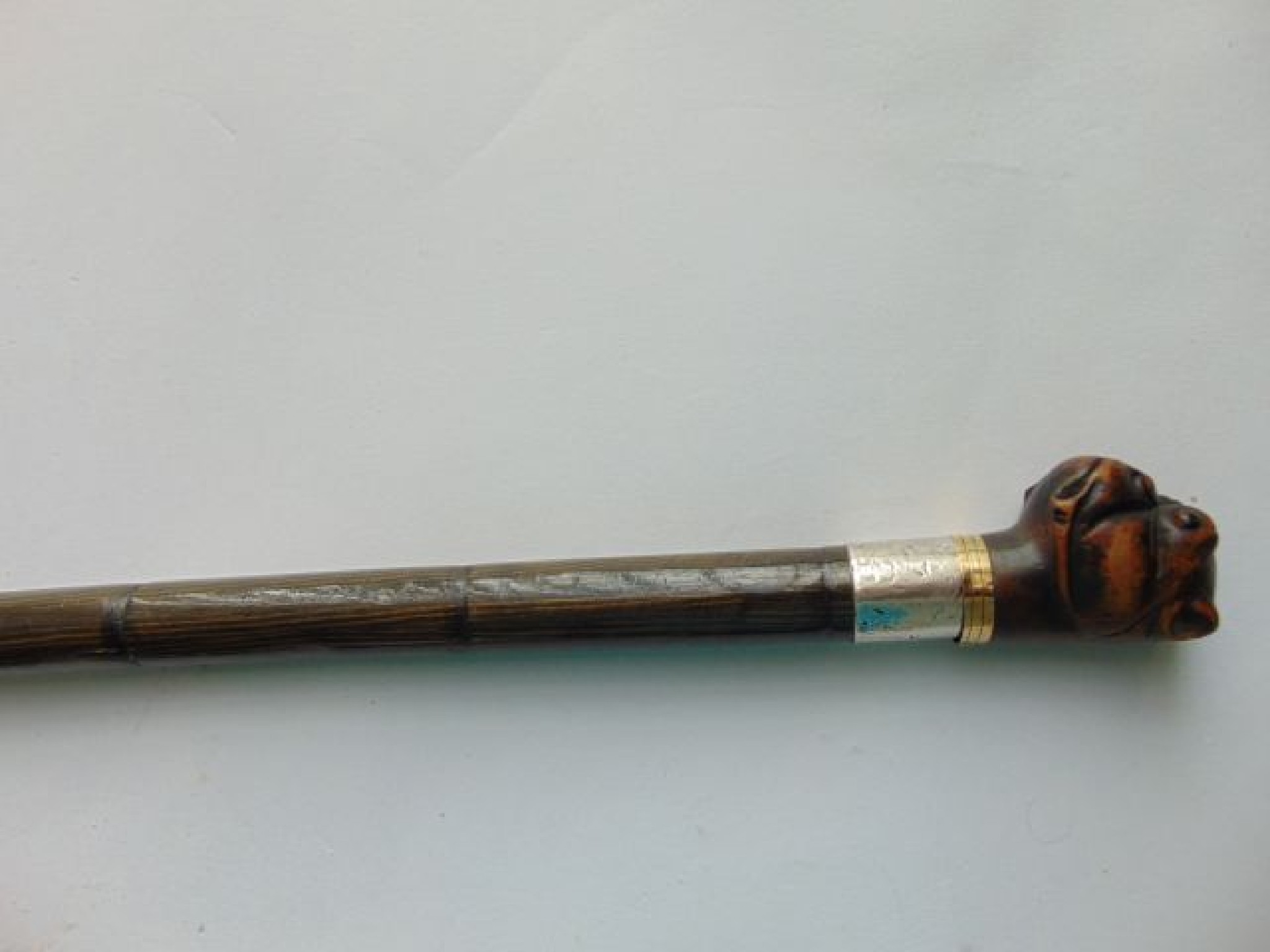 Appraisal: A polished bamboo walking cane terminating in a carved handle