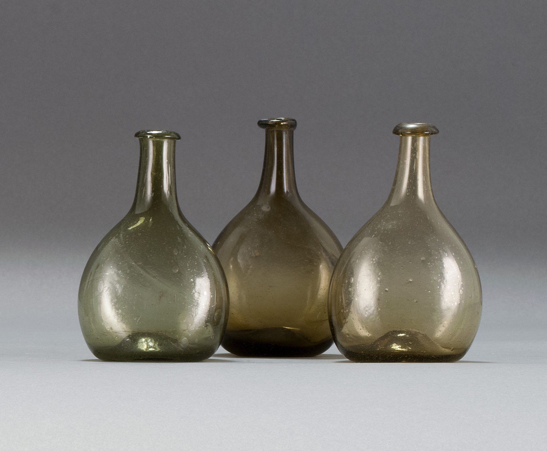 Appraisal: THREE FREE-BLOWN GLASS CHESTNUT FLASKS Early th CenturyIn green and