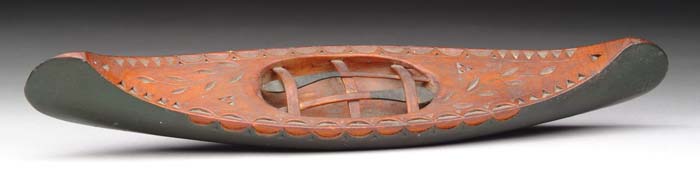 Appraisal: PAINTED AND CARVED MINIATURE CANOE Solid wood canoe has chip