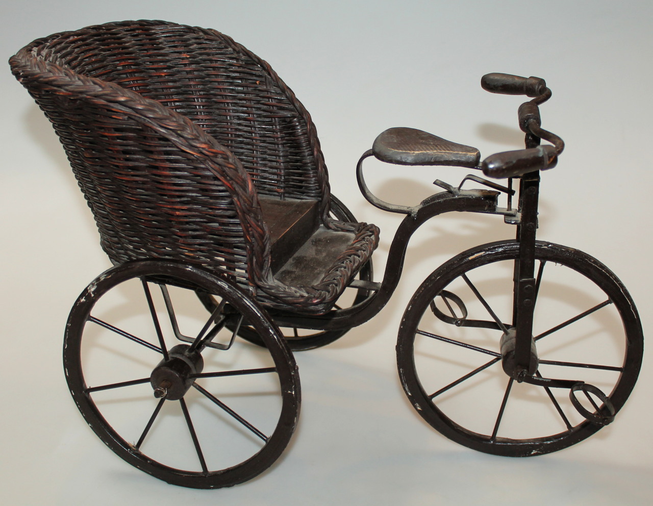 Appraisal: A thC miniature tricycle with wickerwork seat and metal frame