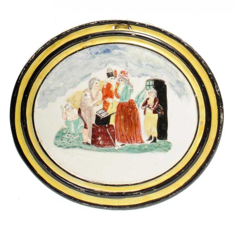 Appraisal: A CREAMWARE MOULDED OVAL PLAQUE painted with a wedding at