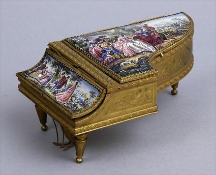 Appraisal: CONTINENTAL PICTORIAL ENAMEL-MOUNTED GILT-METAL PIANO-FORM MUSIC BOX The hinged lid