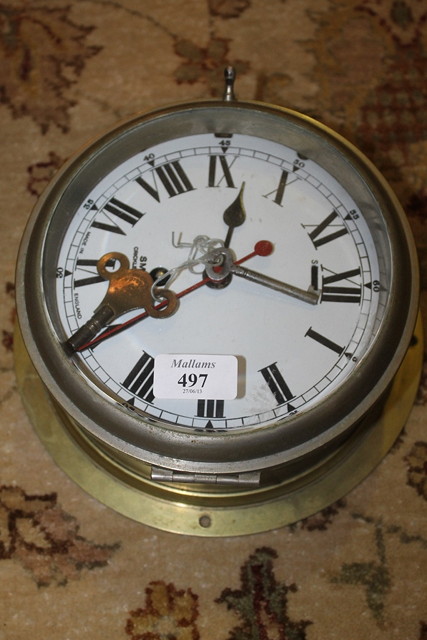 Appraisal: A BRASS CASED SHIPS CLOCK with enamelled dial by Smiths