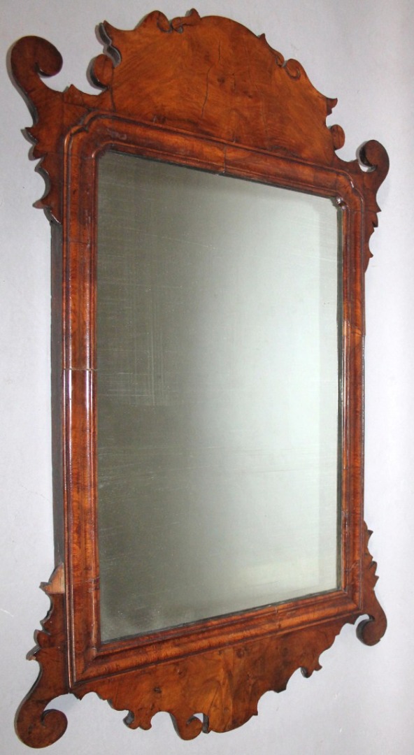 Appraisal: A thC walnut framed pier glass mirror in a shaped