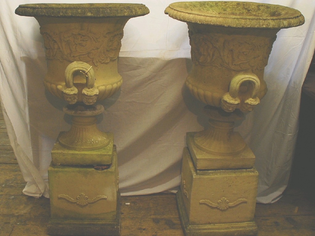 Appraisal: PAIR OF COMPOSITE STONE GARDEN URNS of two handled campana