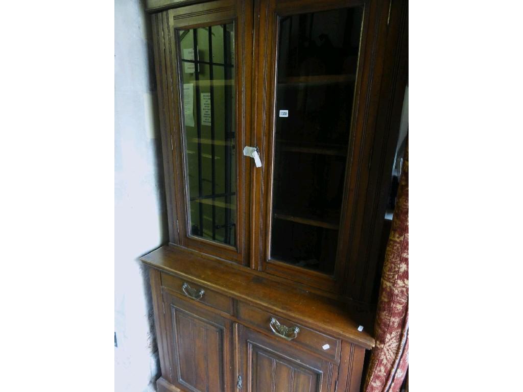 Appraisal: An Edwardian walnut library bookcase the lower section enclosed by