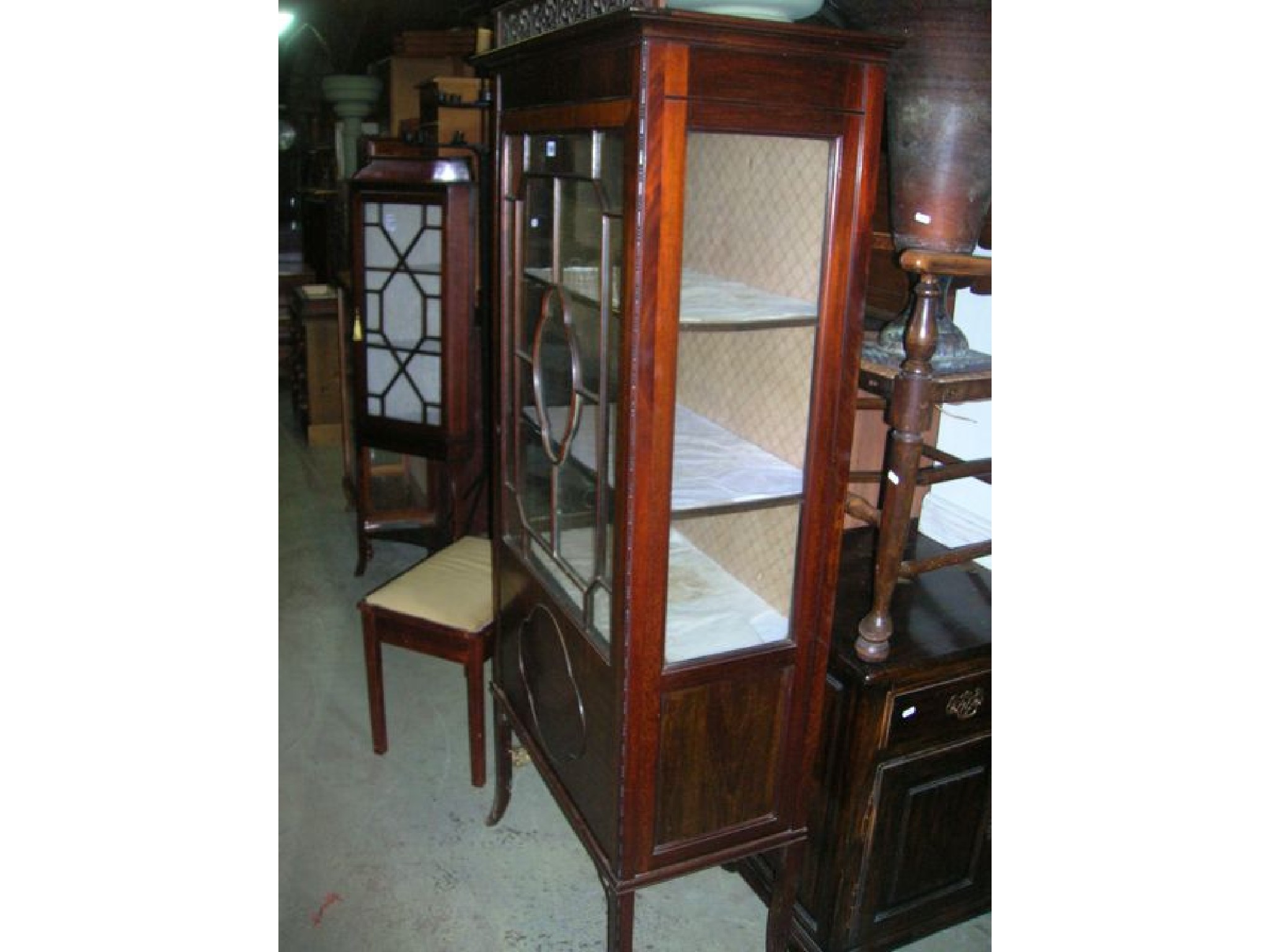 Appraisal: An Edwardian mahogany freestanding display cabinet with pierced fretwork gallery