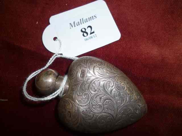 Appraisal: A SMALL SILVER MOUNTED HEART SHAPED PERFUME BOTTLE high