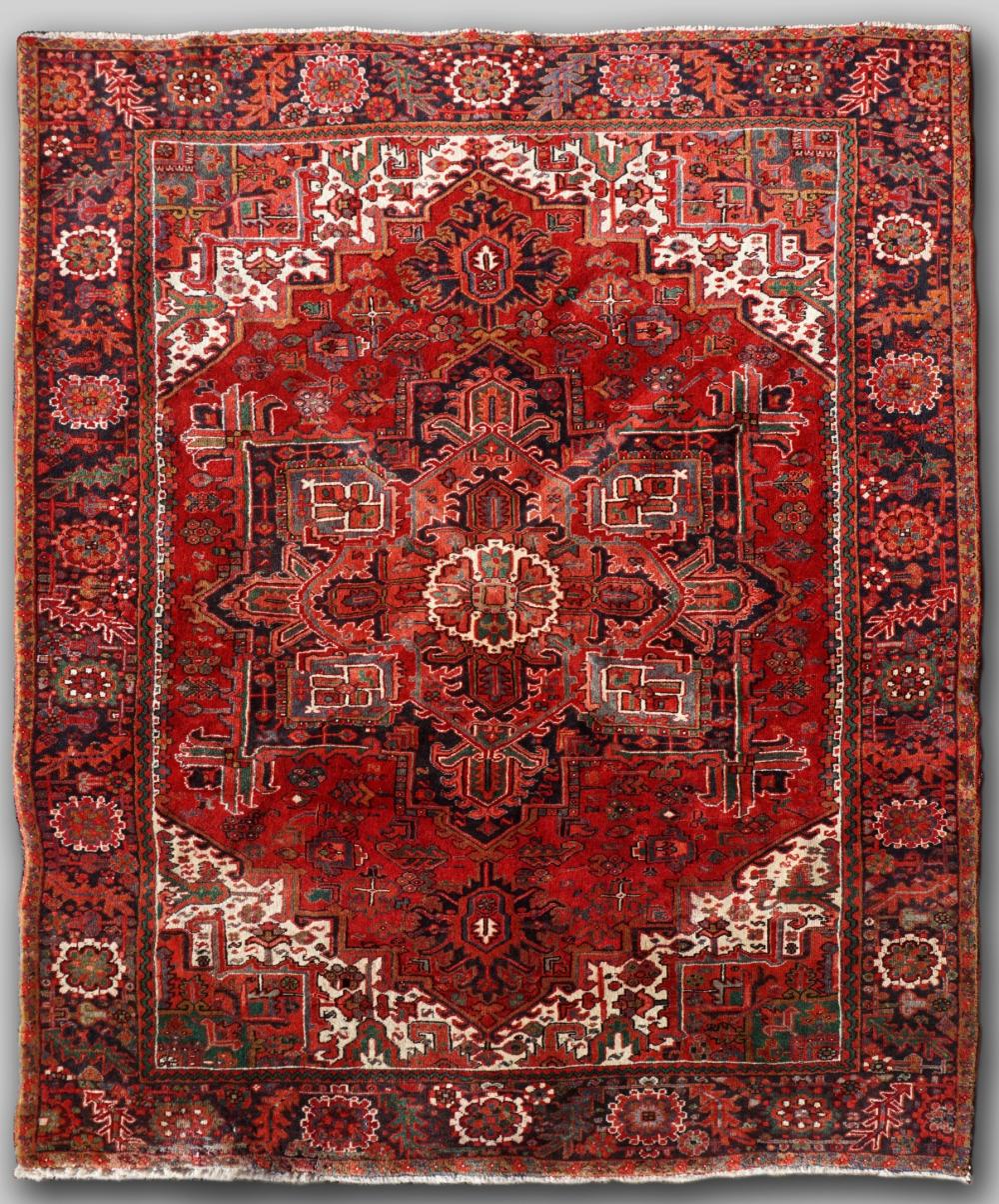 Appraisal: PERSIAN HERIZ HAND KNOTTED WOOL RUG predominantly red tones with