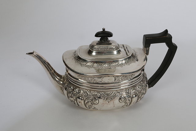 Appraisal: A GEORGE V SILVER TEAPOT oval shaped and chased body