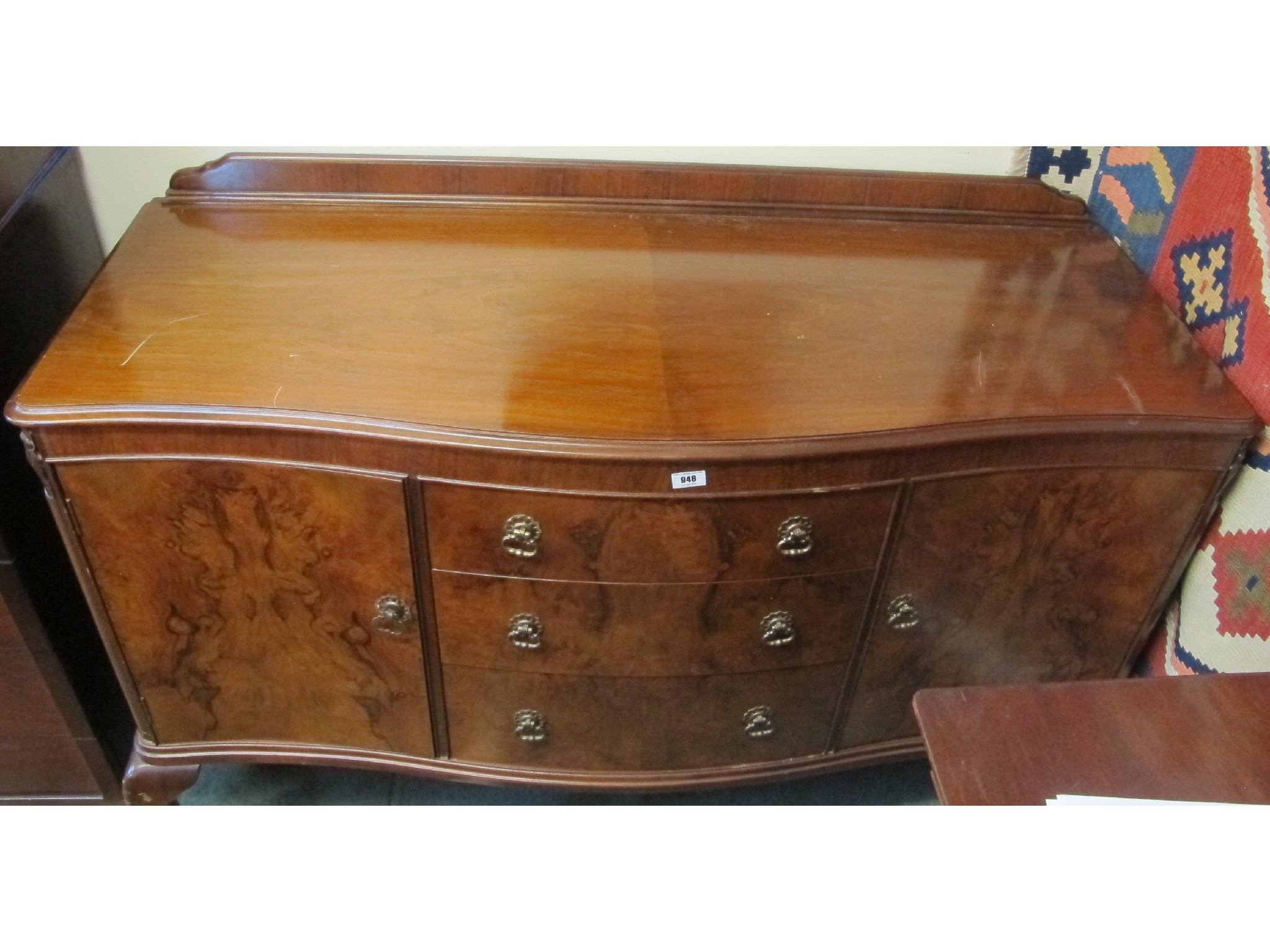 Appraisal: A serpentine walnut sideboard