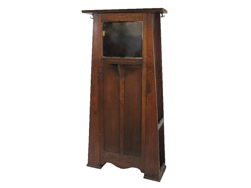 Appraisal: An oak hallstand with mirror door and shelf flanked by