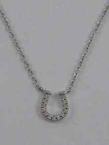 Appraisal: A diamond set horseshoe pendant in ct white gold signed