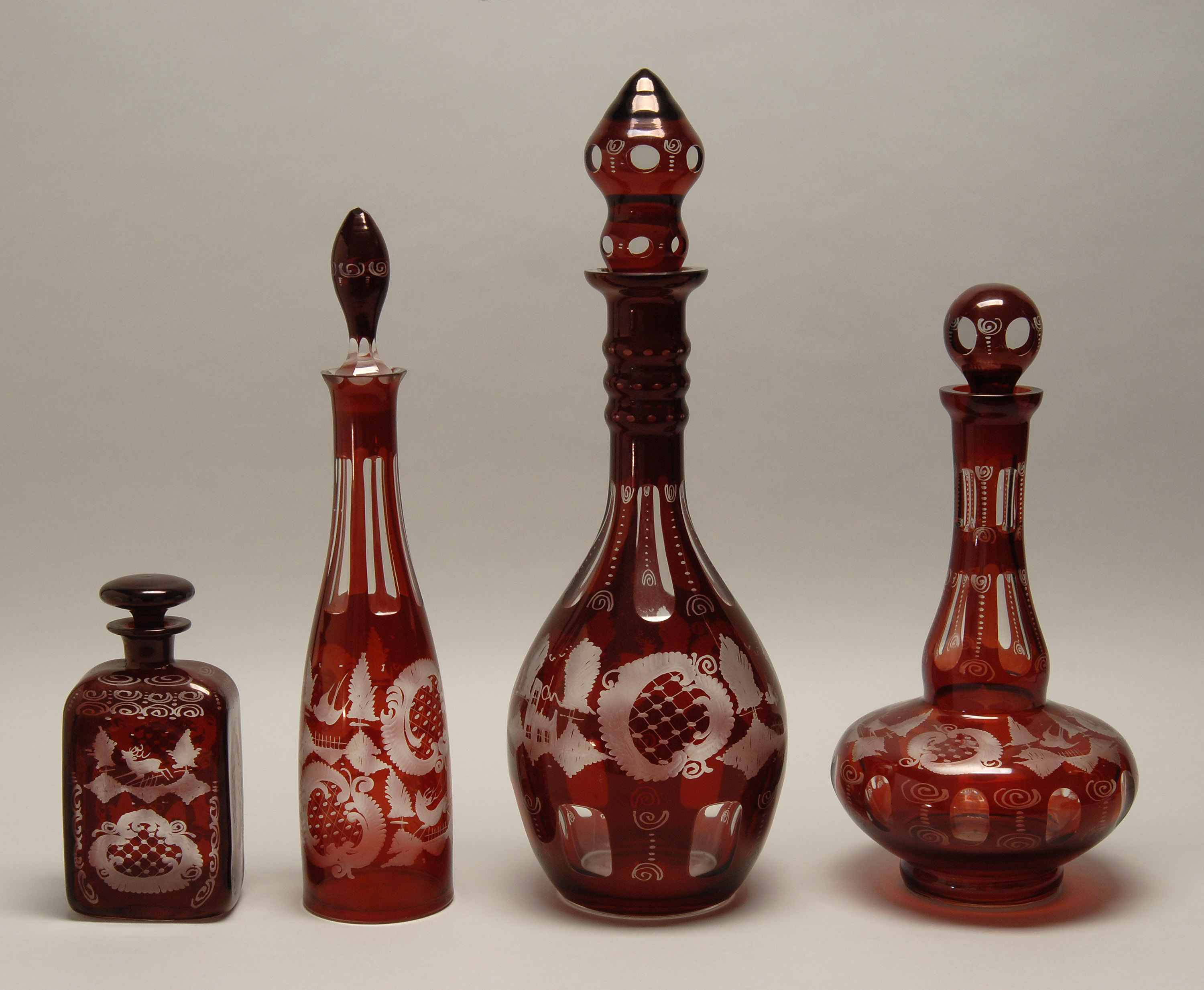 Appraisal: FOUR BOHEMIAN RUBY CUT-TO-CLEAR GLASS DECANTERS th CenturyAll with stoppers