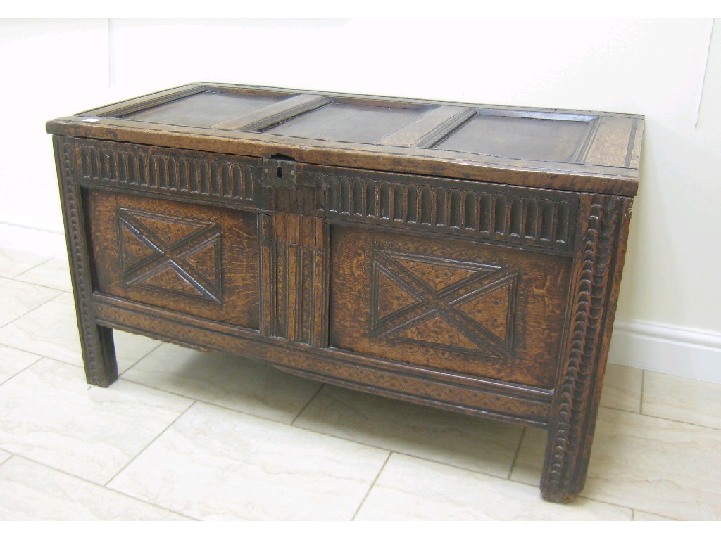 Appraisal: An antique oak Coffer with three panelled top and carved