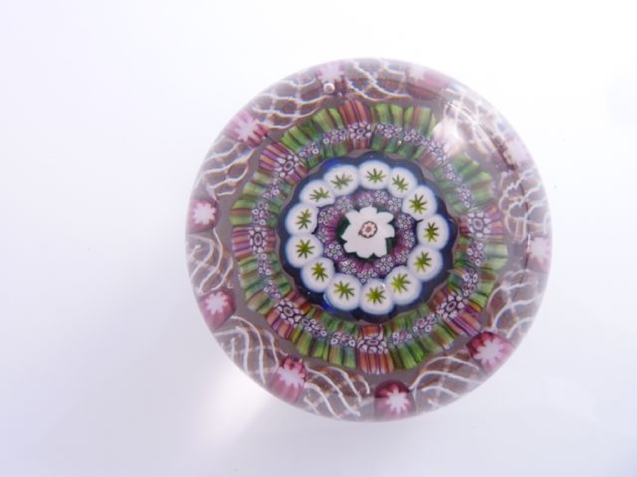 Appraisal: A Millefiori glass paperweight with central white flower encased within