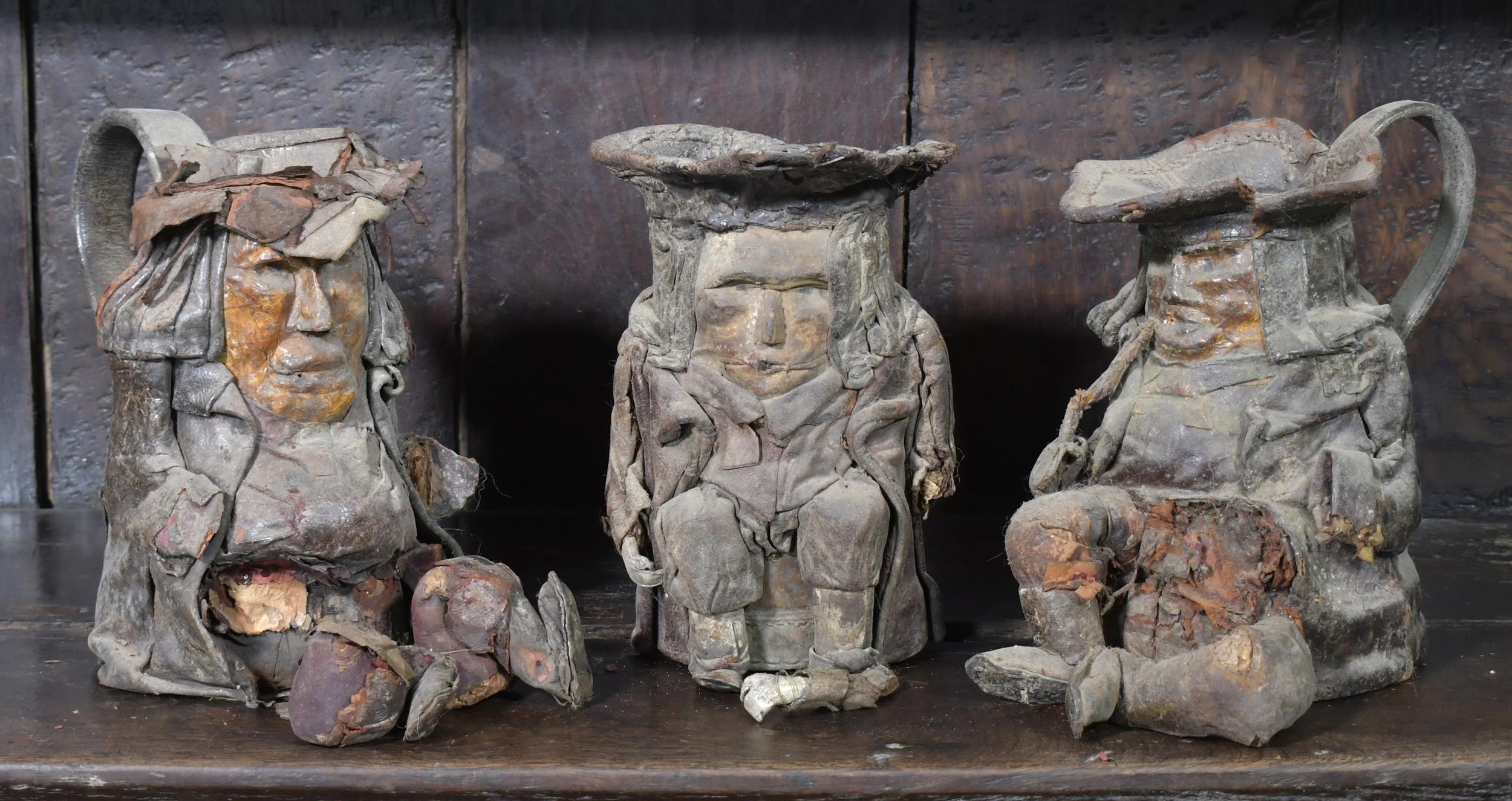 Appraisal: THREE TH C LEATHER TOBY JUGS Three traditional th C