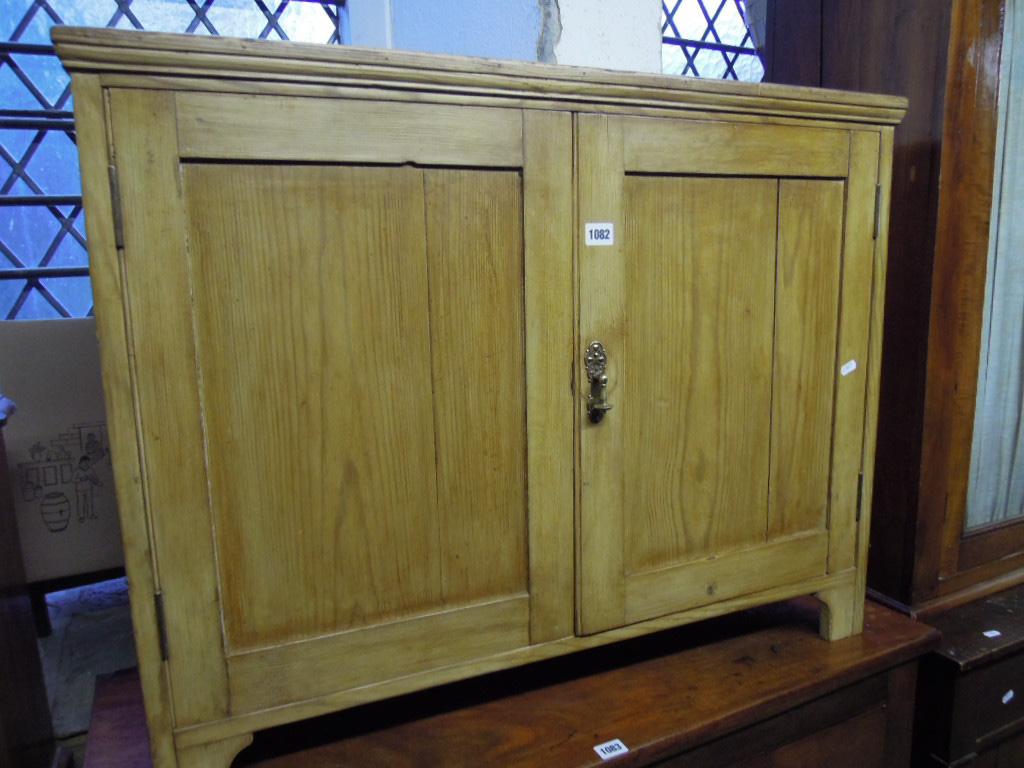 Appraisal: A dwarf stripped pine side cupboard enclosed by a pair