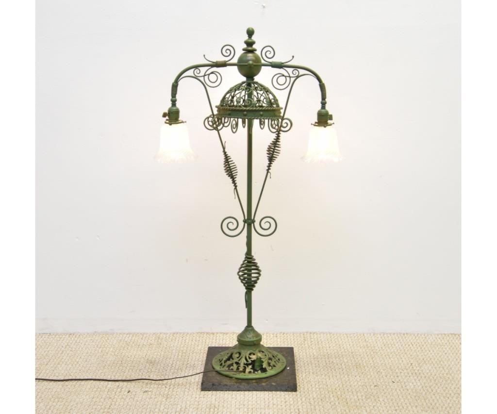 Appraisal: Wrought iron green painted double armed standing lamp mounted on