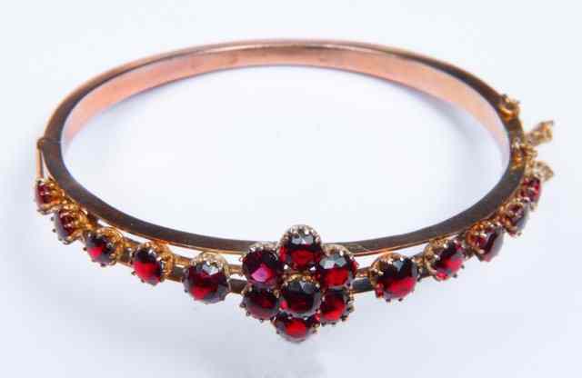 Appraisal: AN UNMARKED BANGLE with stylised ruby setting