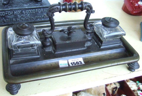 Appraisal: A bronze desk stand th century the loop handle flanked