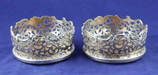 Appraisal: A pair of Victorian pierced silver wine coasters with foliate