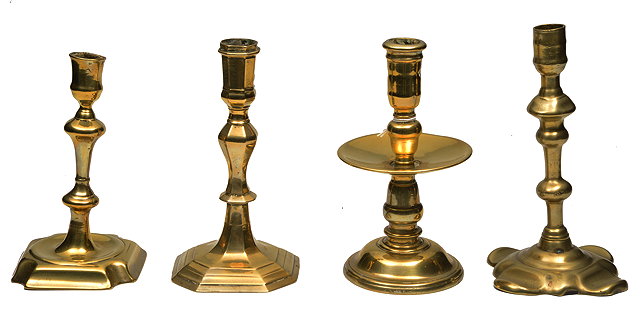 Appraisal: A GROUP OF FOUR ANTIQUE BRASS CANDLESTICKS one with wax