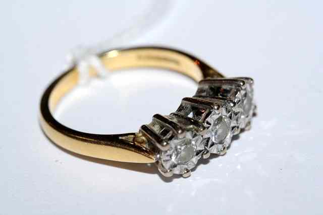 Appraisal: A THREE STONE DIAMOND SET DRESS RING with brilliant cut