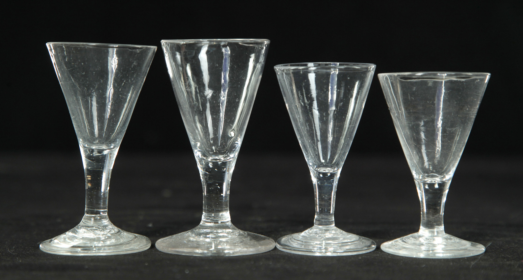 Appraisal: FOUR CLEAR BLOWN CORDIALS American st half- th century V