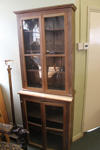 Appraisal: A PITCH PINE TWO TIER CUPBOARD enclosed by glazed panel