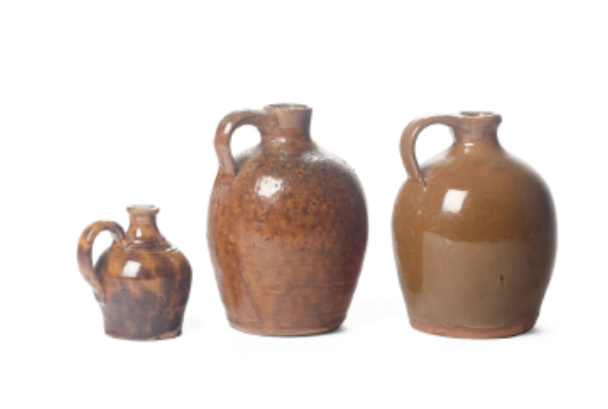 Appraisal: THREE NEW ENGLAND GLAZED REDWARE JUGS NINETEENTH CENTURY The first