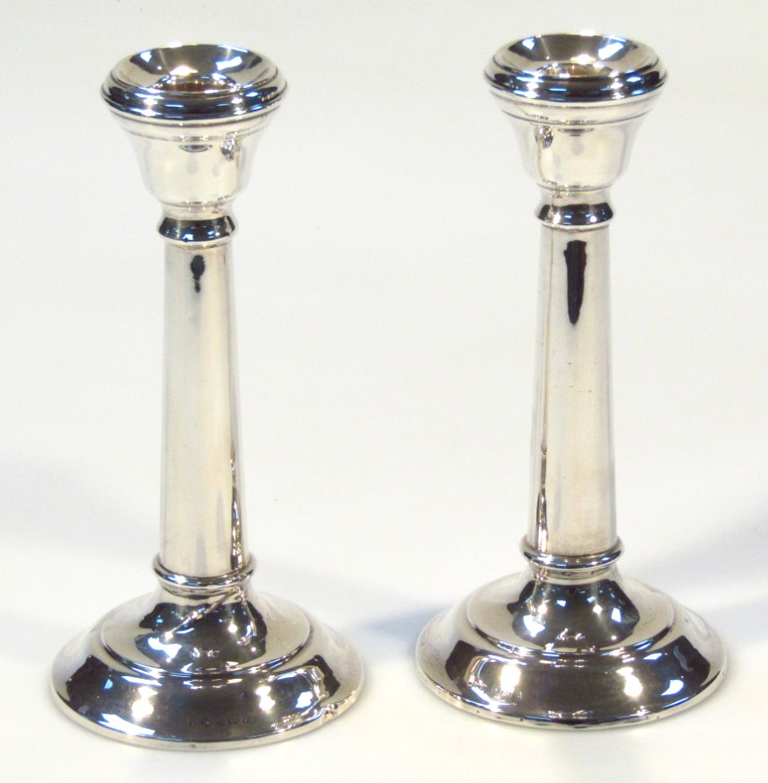 Appraisal: A pair of George V silver candlesticks the compressed dish