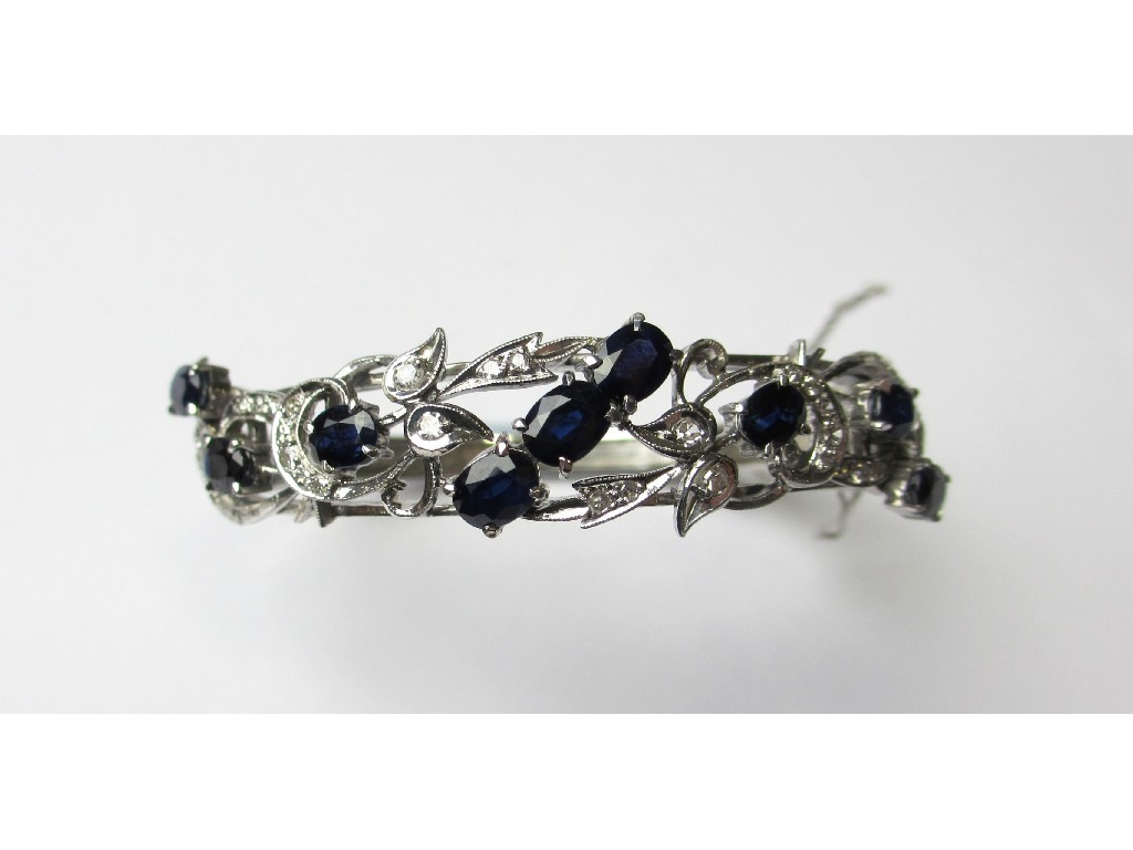 Appraisal: A nine carat white gold sapphire and diamond set bangle