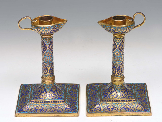 Appraisal: A PAIR OF INDIAN ISLAMIC COPPER GILT AND ENAMEL CANDLESTICKS