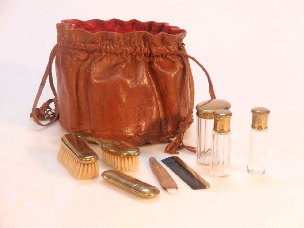 Appraisal: A leather drawstring bag containing a set of miniature toilet