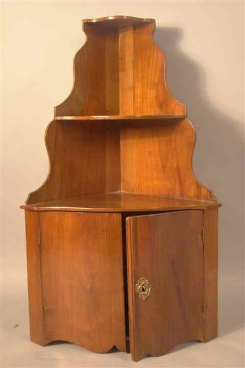 Appraisal: CONTINENTAL CHERRYWOOD HANGING CORNER SHELF AND CABINET with graduated serpentine