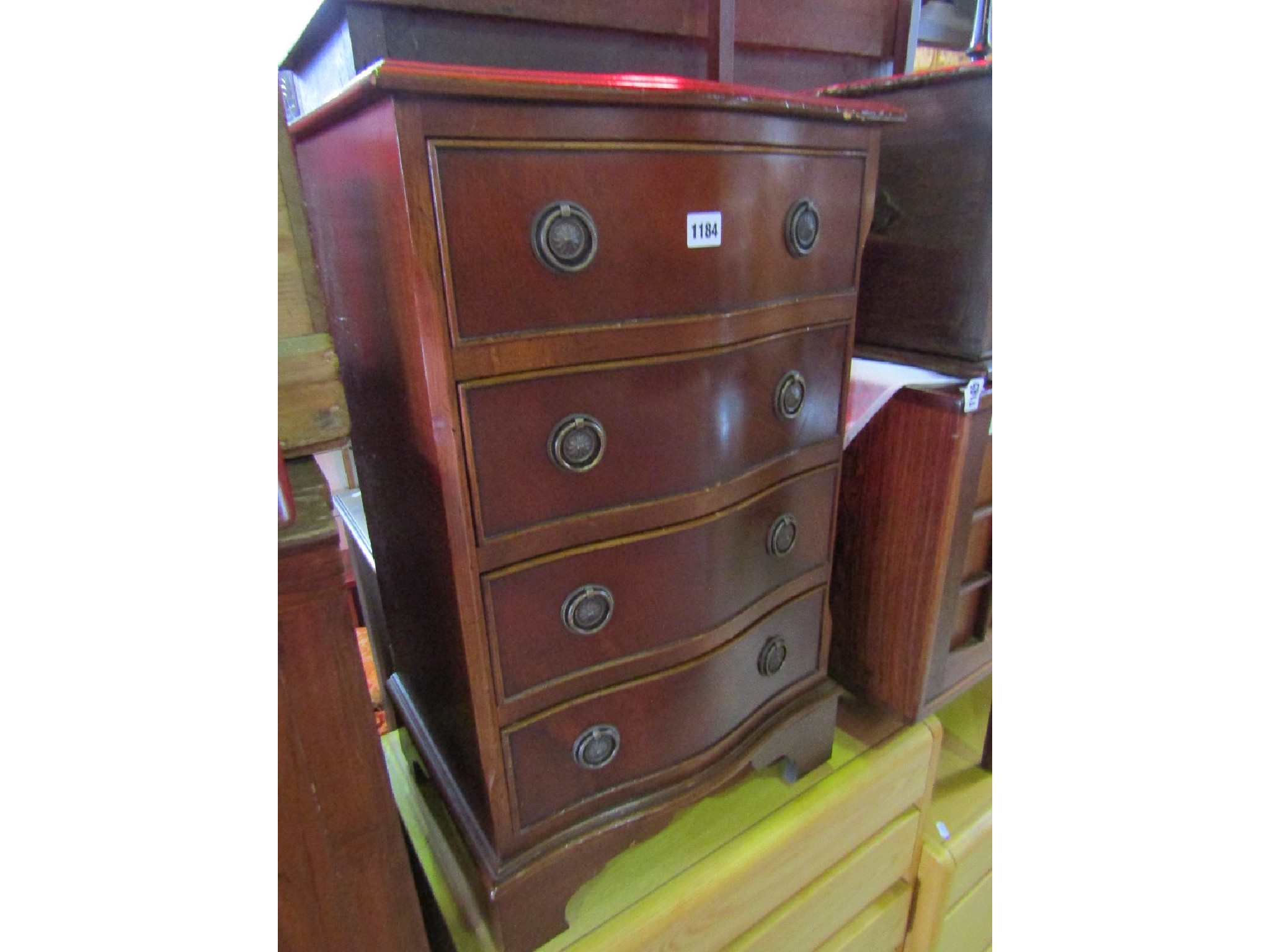 Appraisal: A small Georgian style mahogany veneered chest the serpentine front