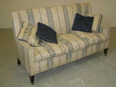 Appraisal: A MAHOGANY FRAMED HIGH BACK SOFA upholstered in a cream