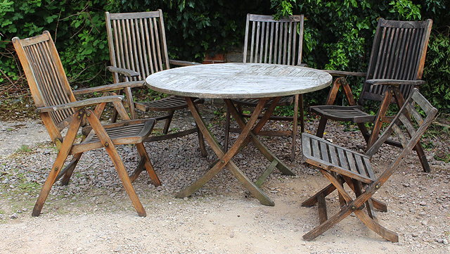 Appraisal: A CIRCULAR TEAK FOLDING GARDEN TABLE cm diameter together with