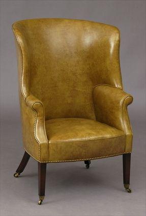 Appraisal: ENGLISH MAHOGANY AND LEATHER-UPHOLSTERED WING ARMCHAIR The curved back and