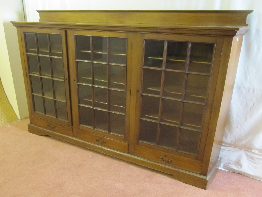 Appraisal: An Edwardian mahogany bookcase with a mahogany pediment raised over