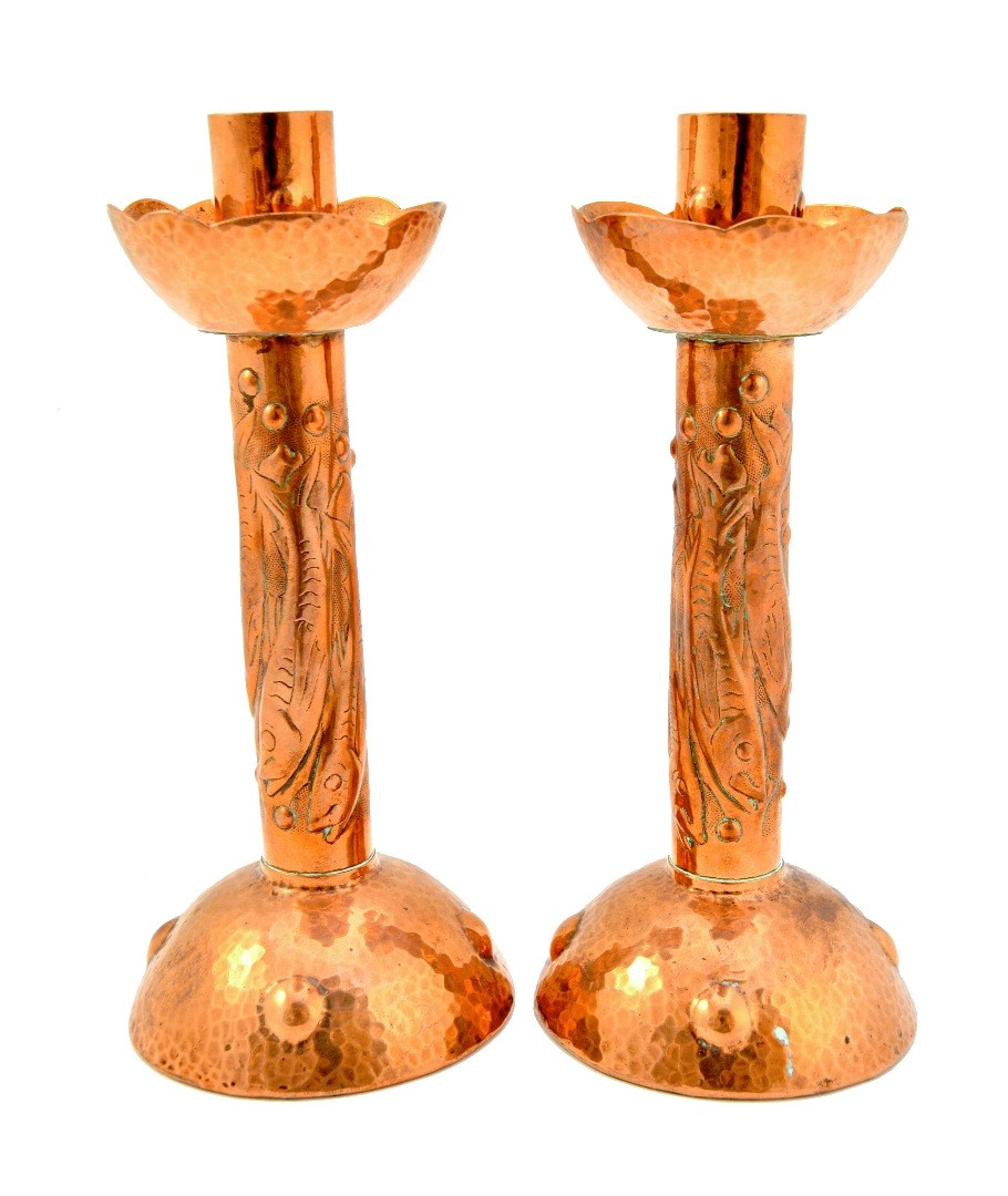 Appraisal: A pair of Newlyn copper candlesticks each with embossed fish