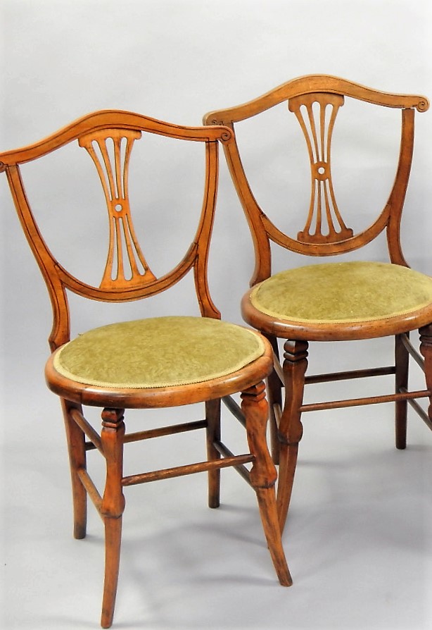 Appraisal: A pair of stained beech single chairs with shield shape