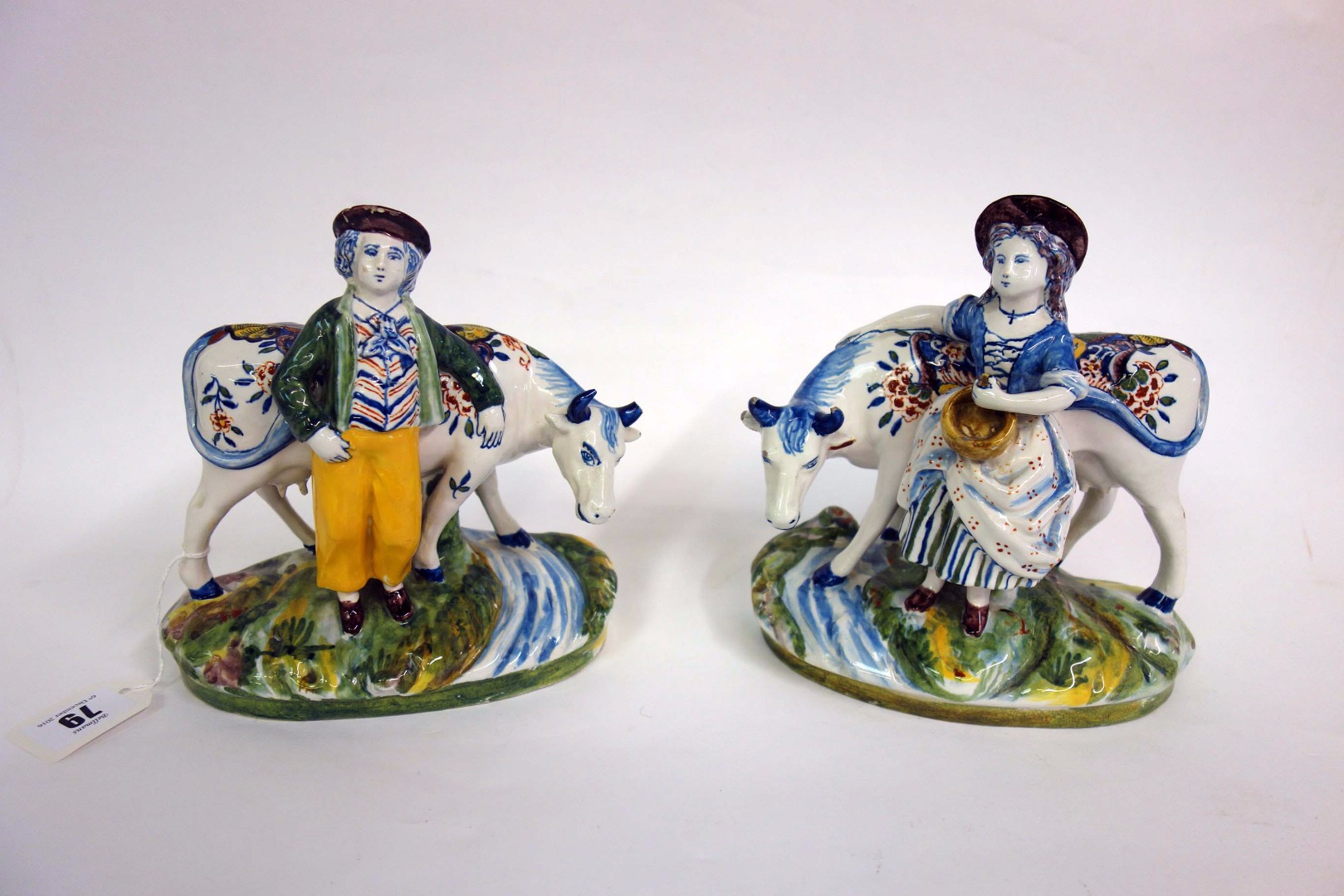 Appraisal: A pair of Delft pottery figures standing beside cows th