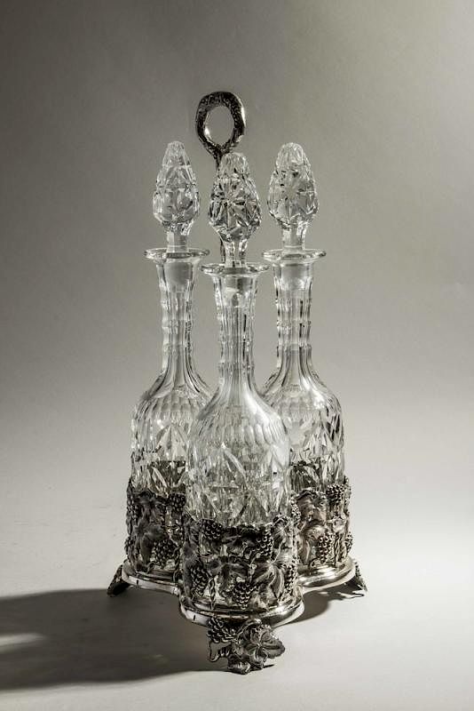 Appraisal: Decorative Stand with Decanters Decorative silverplate stand with three stoppered