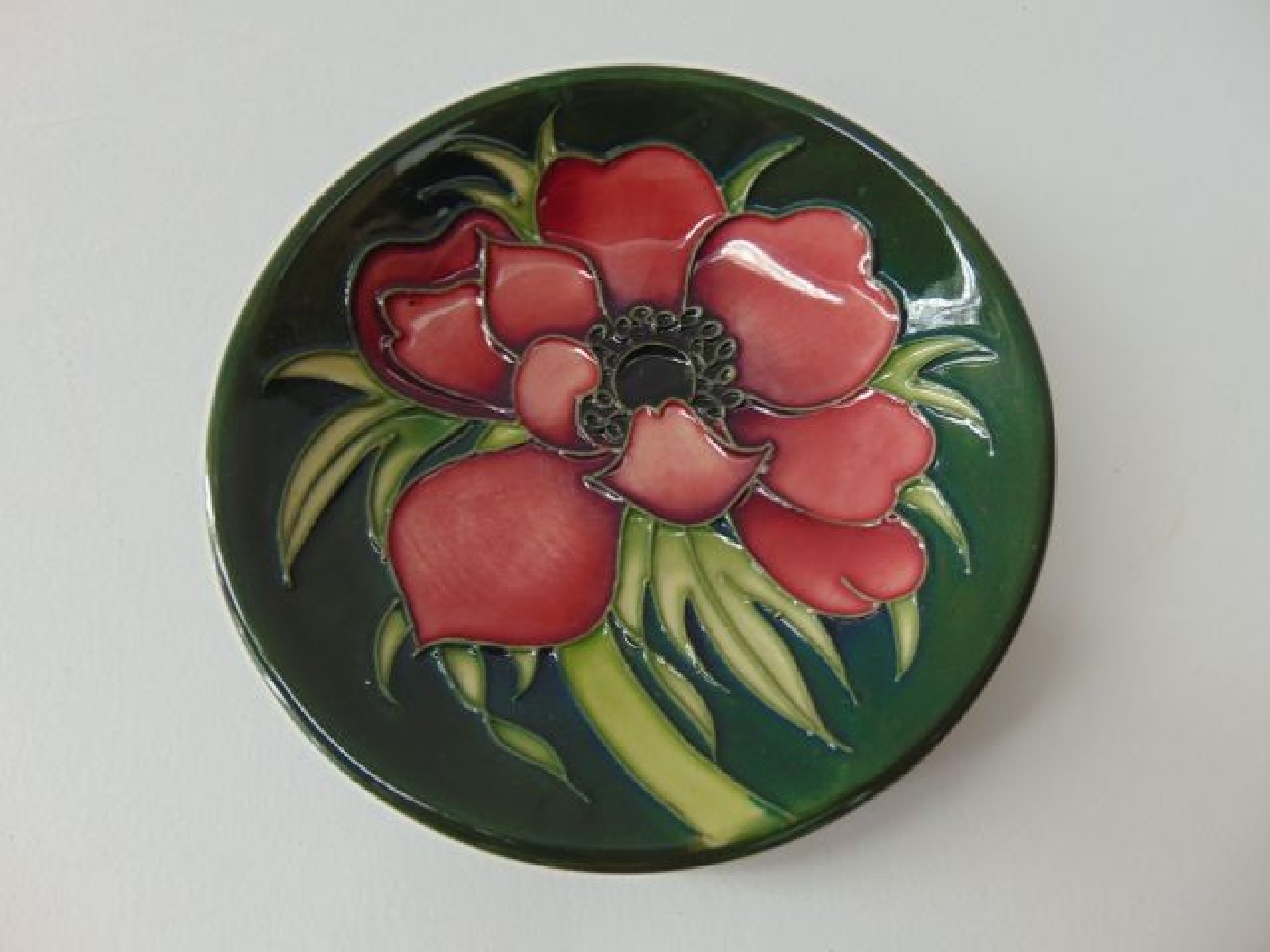 Appraisal: A Moorcroft green ground dish of circular form with pink