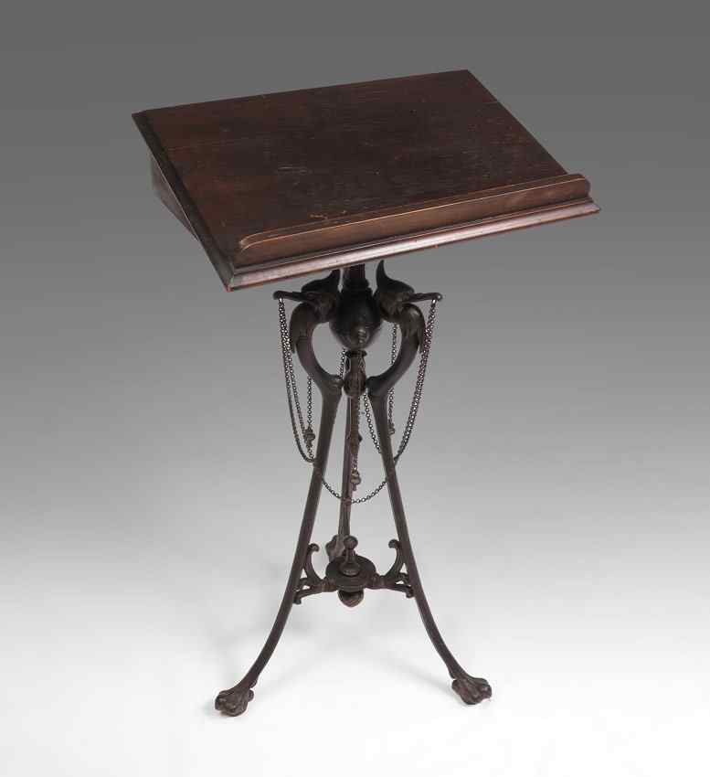 Appraisal: FIGURAL AESTHETIC MOVEMENT DICTIONARY STAND Cast metal tri foot base