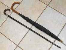 Appraisal: An ebonised mahogany walking stick with horn handle and silver