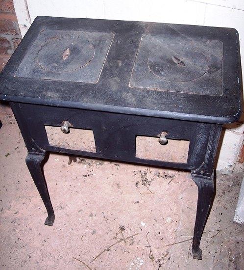 Appraisal: An iron stove the two hobs over two compartments with