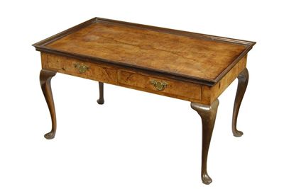 Appraisal: A walnut coffee table the quarter veneered top with a